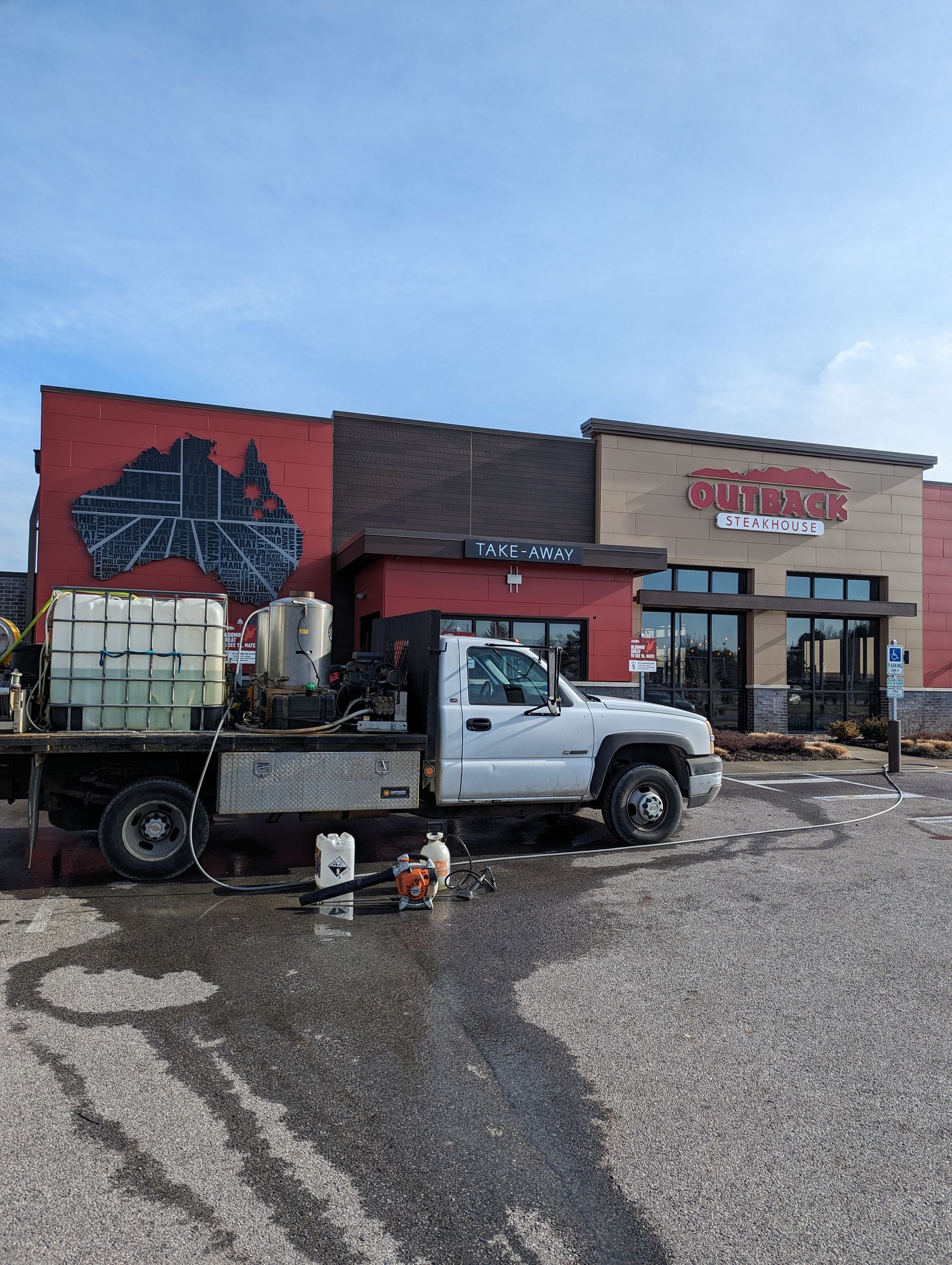 A white truck is parked in front of a building.