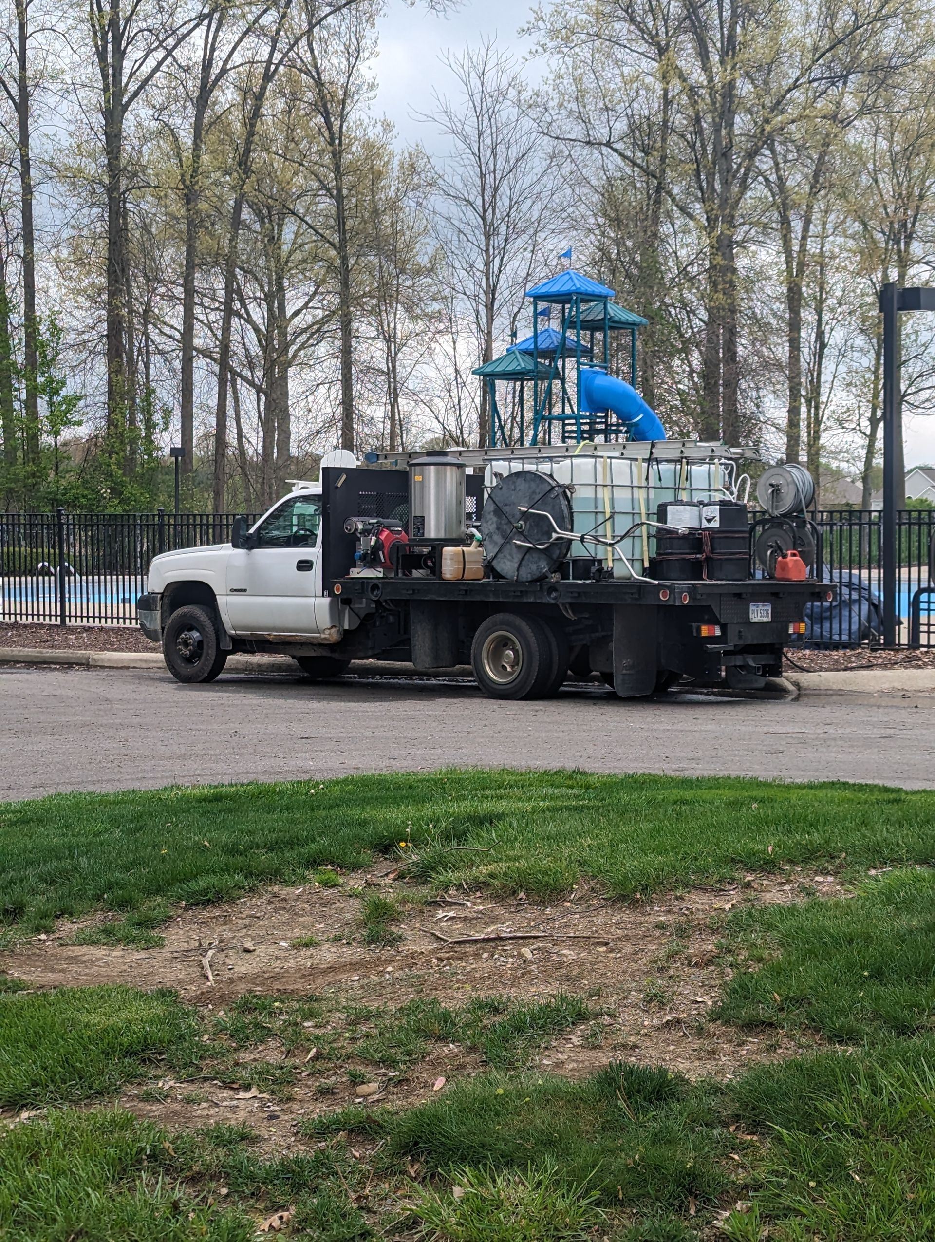A white truck is parked in front of a water park.