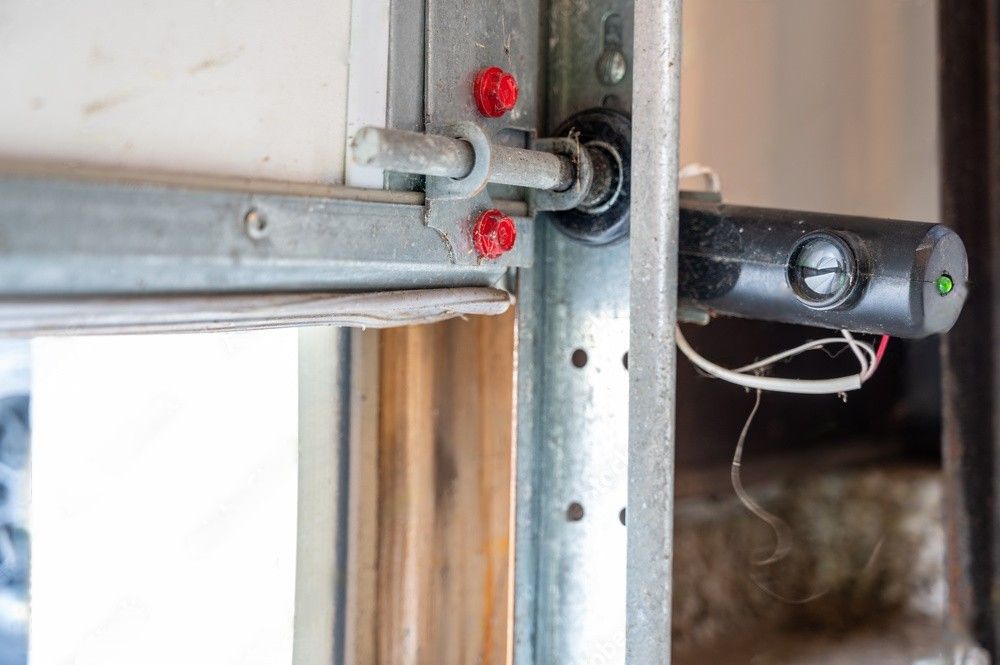 Single garage door safety sensor receptor eye, designed to halt door operation when the beam is interrupted.