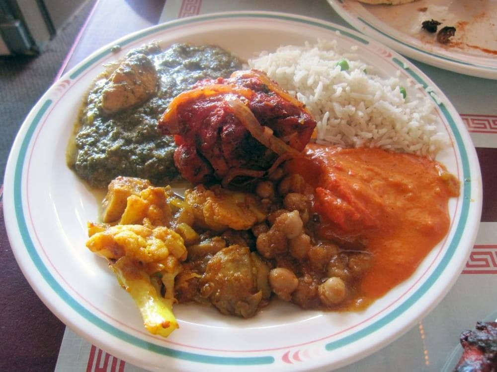 Plate of Indian food: chicken, rice, sauces, chickpeas, and vegetables.