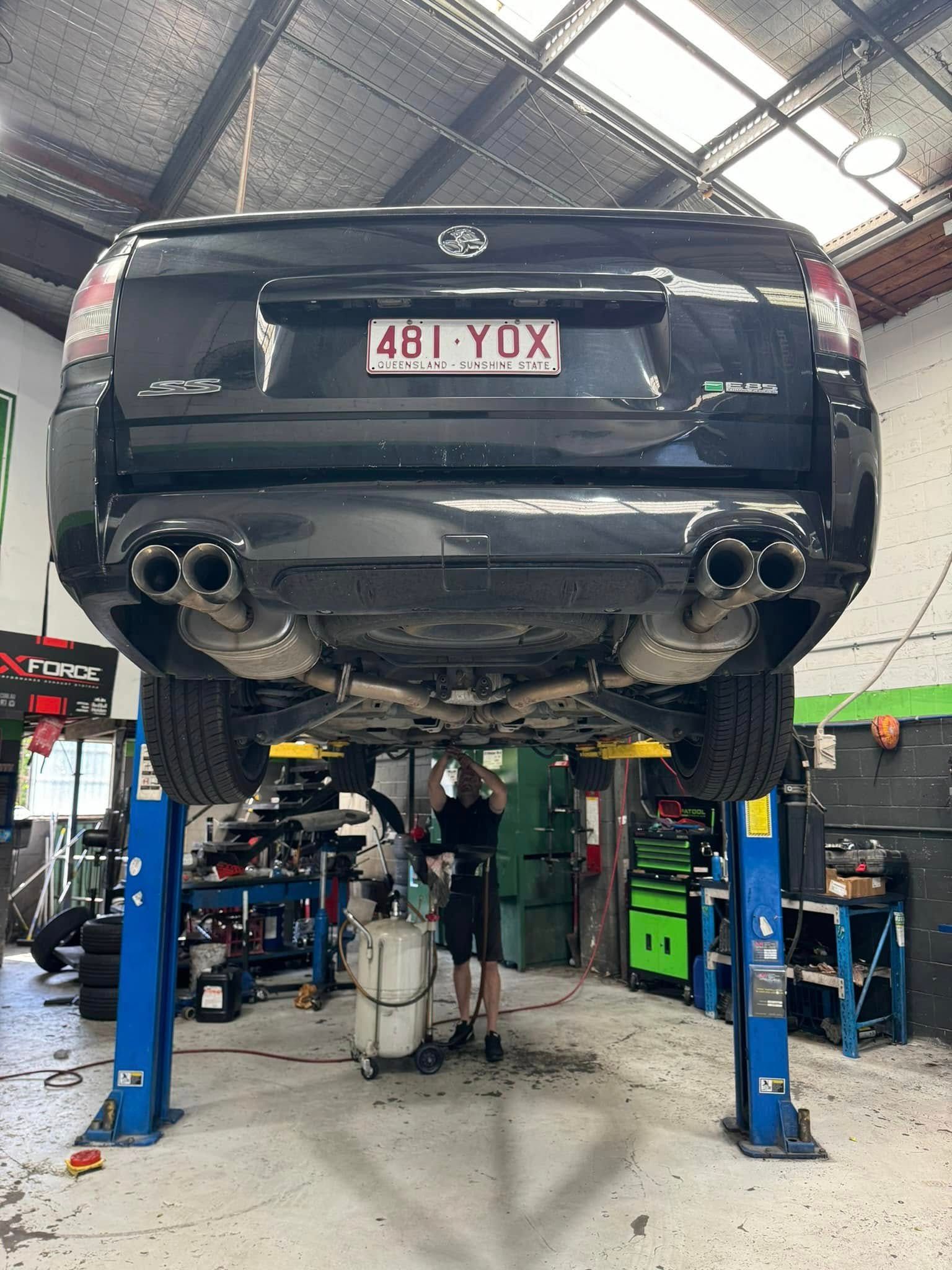 Black Sedan On A Lift In An Auto Repair Shop — Mr Mechanical Auto Service Centre in Southport, QLD