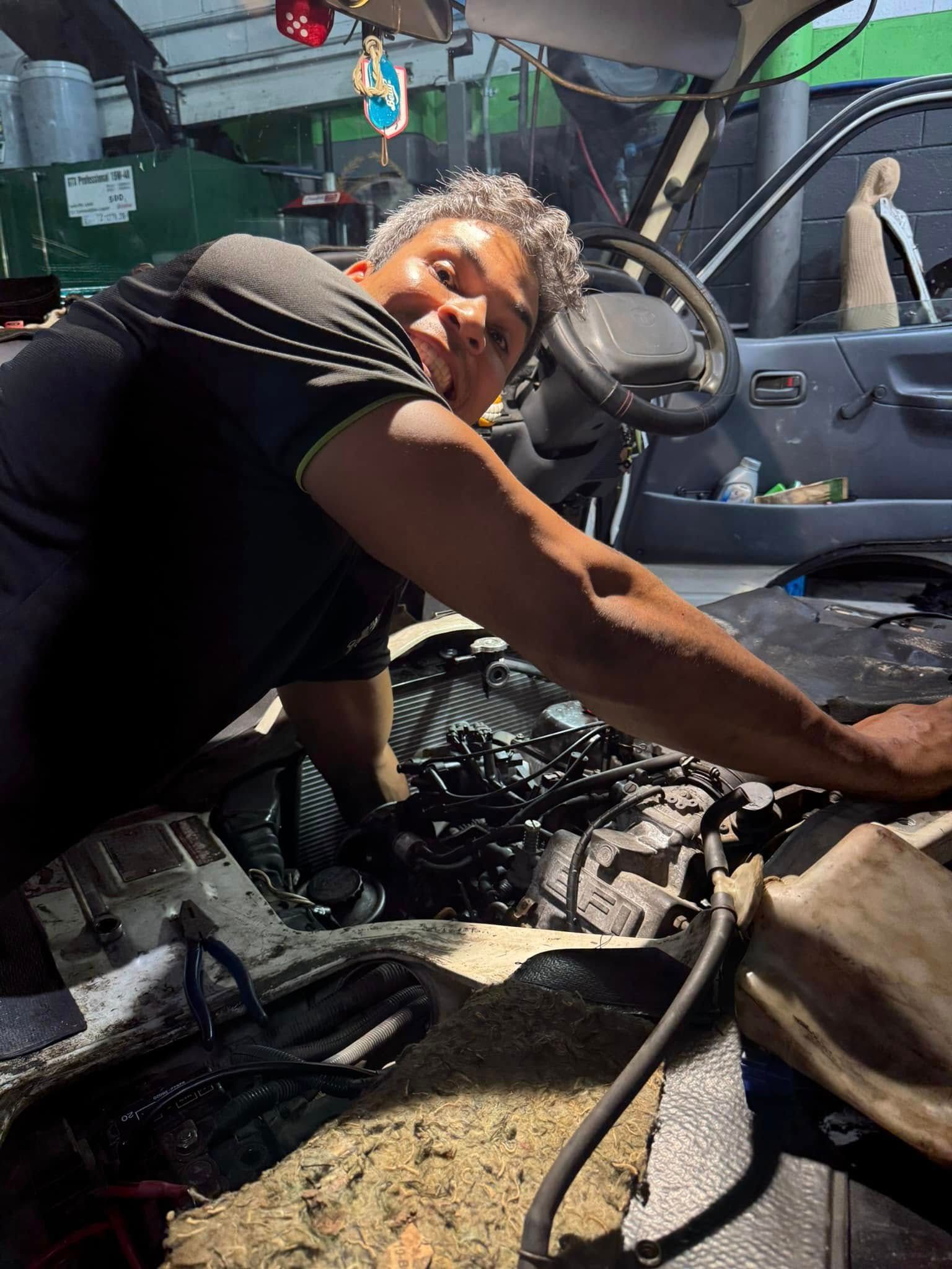 Mechanic Leaning Into An Open Engine Bay — Mr Mechanical Auto Service Centre in Southport, QLD
