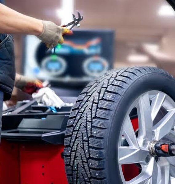 Mechanic Balancing A Car Tyre On A Wheel Balancing Machine — Mr Mechanical Auto Service Centre in Southport, QLD
