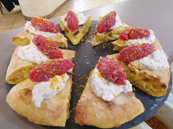 Piatto di pane a fette con panna bianca e marmellata rossa su un vassoio da portata nero