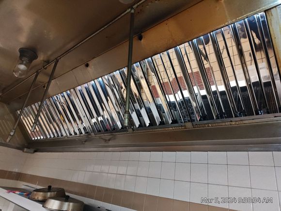 Inside of a commercial kitchen hood. Stainless steel grates and vent.