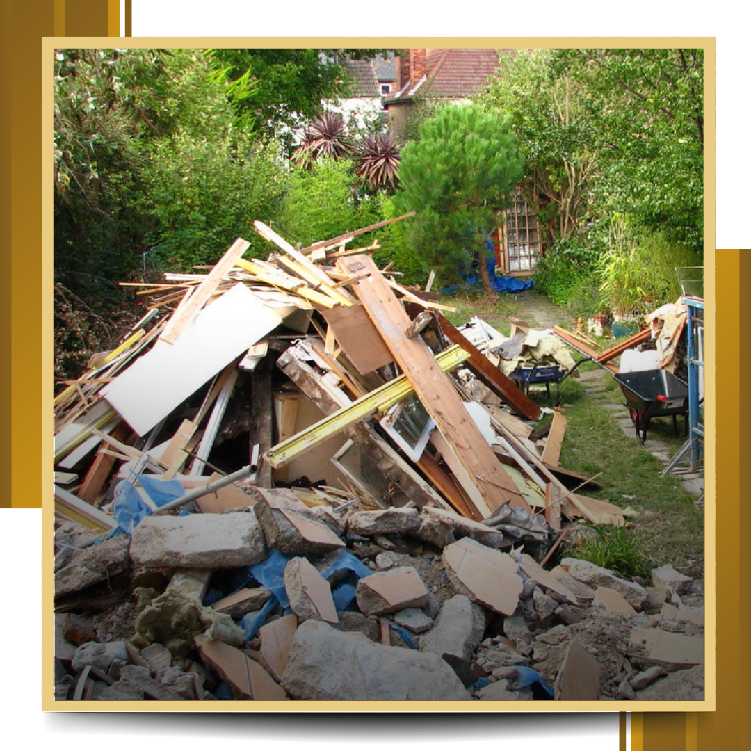 Pile of demolition debris in a backyard, including wood, concrete, and other materials.