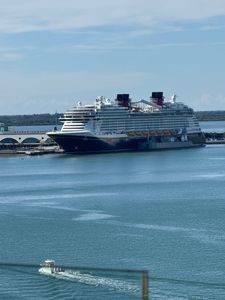 Large white cruise ship docked at a harbor under a clear blue sky