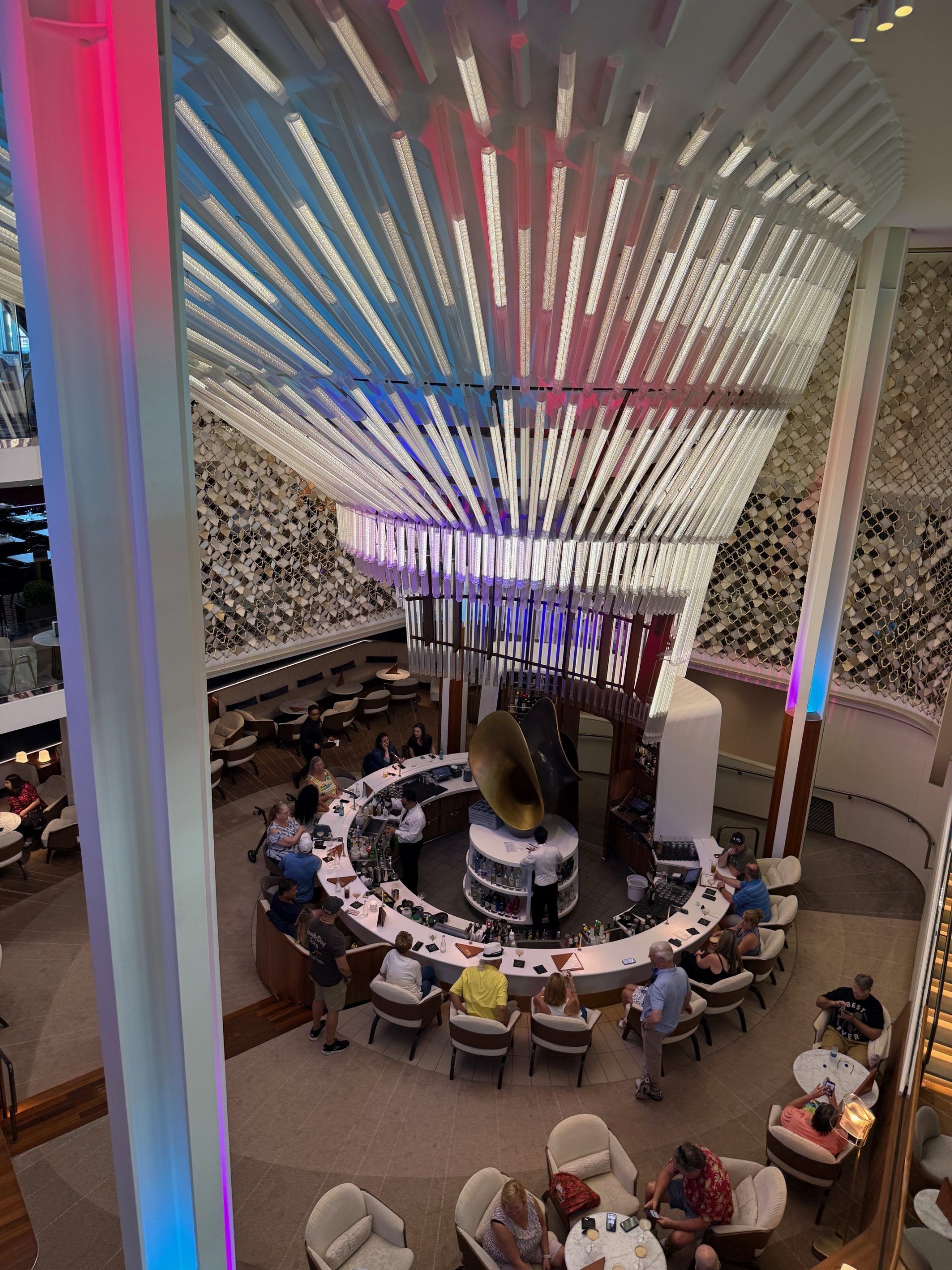 Circular indoor dining area beneath colorful illuminated ceiling panels
