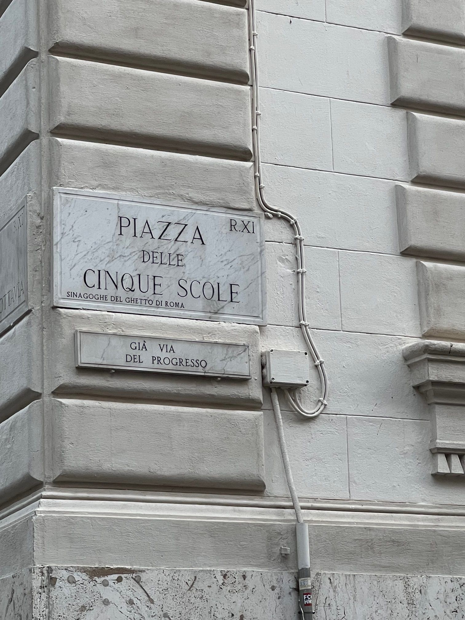 Weathered street plaque on a stone building wall reading “Piazza Civour.”