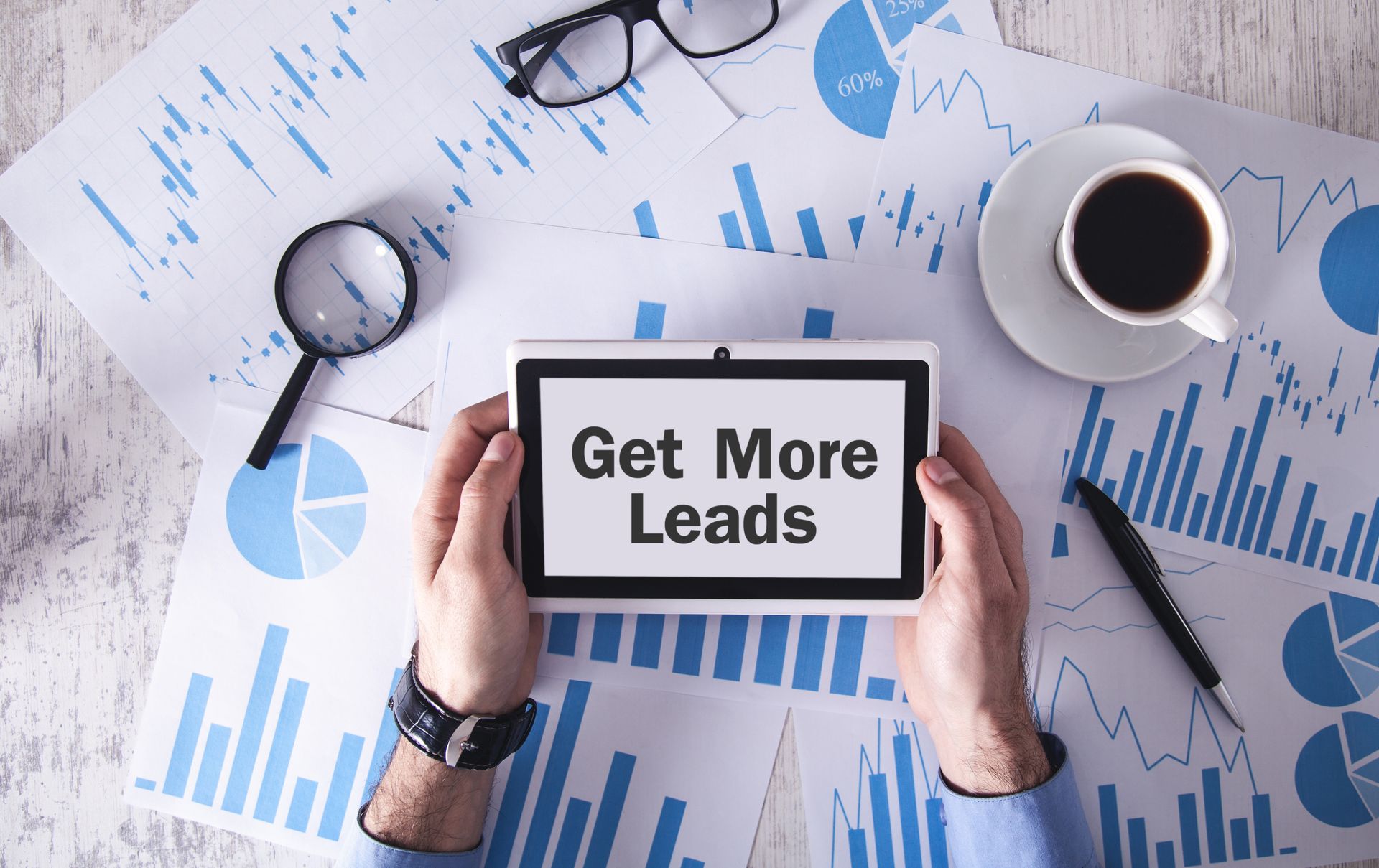 A person is holding a tablet with the words `` get more leads '' on it.