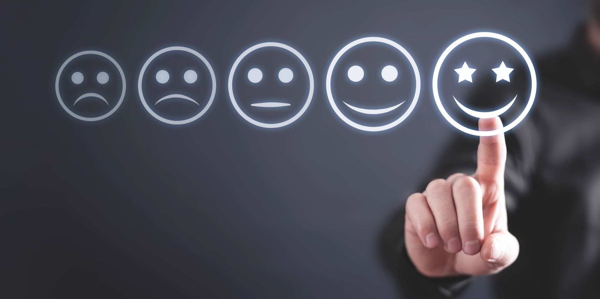 A person is pointing at a smiley face on a screen.