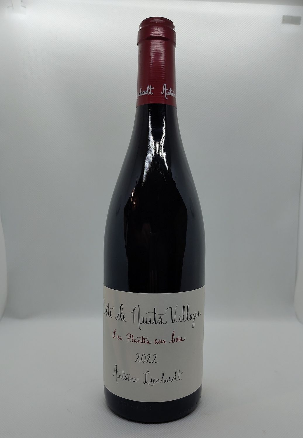 Une bouteille de champagne est posée sur une étagère en bois.