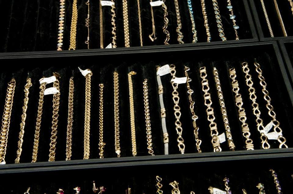 Necklaces displayed in black velvet trays, with gold and silver chains arranged in rows