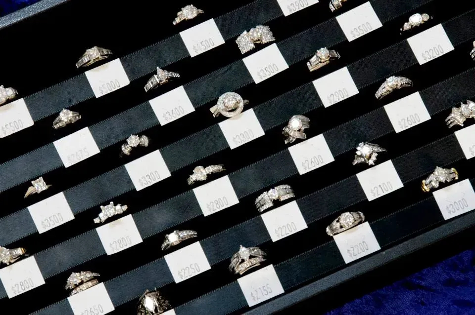White objects arranged in diagonal rows on a black-and-blue background, with small metallic items scattered between them