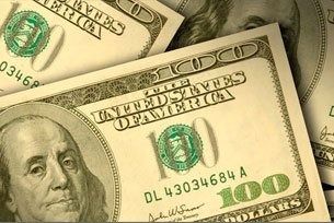 Close-up of U.S. $100 bills stacked and overlapping, with Benjamin Franklin’s portrait visible