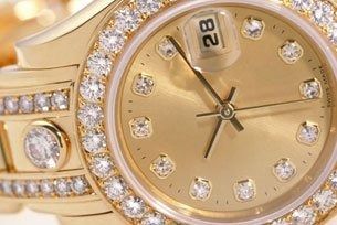 Gold wristwatch with diamond-studded bezel and bracelet, showing date 28.