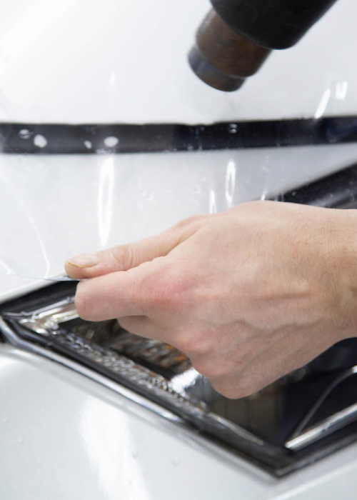 Hand placing a tray under a coffee machine dispenser