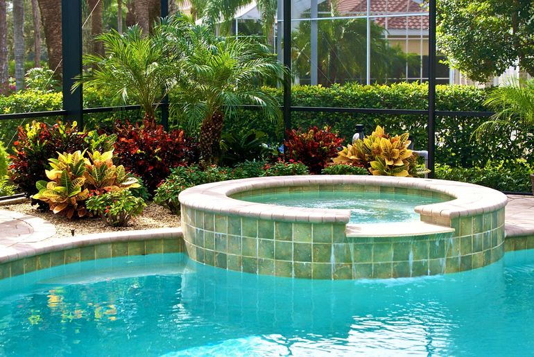 A swimming pool with a hot tub in the middle of it