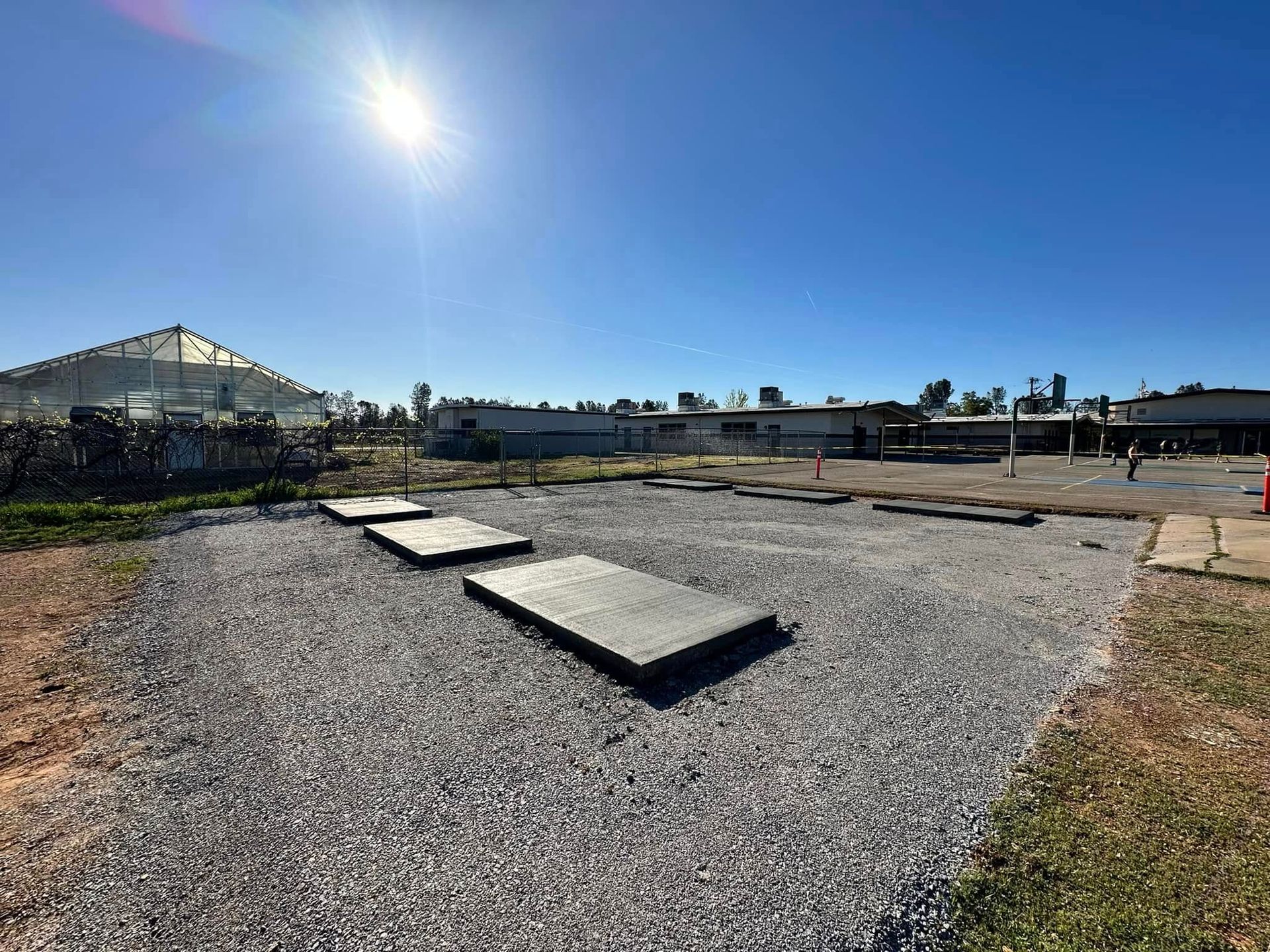 Gravel garden path with stepping stones under a bright blue sky and sun near a greenhouse. Gravel garden path with stepping stones under a bright blue sky and sun near a greenhouse.