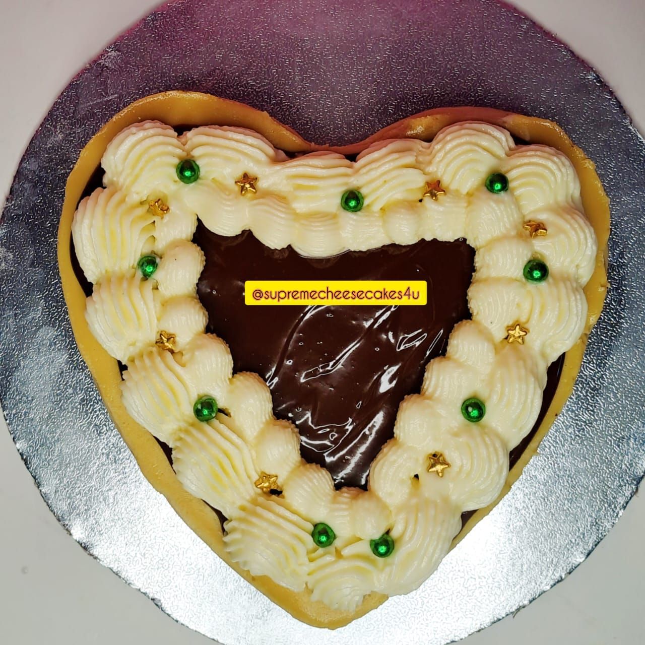 A heart shaped cake that says supreme cheesecake on it