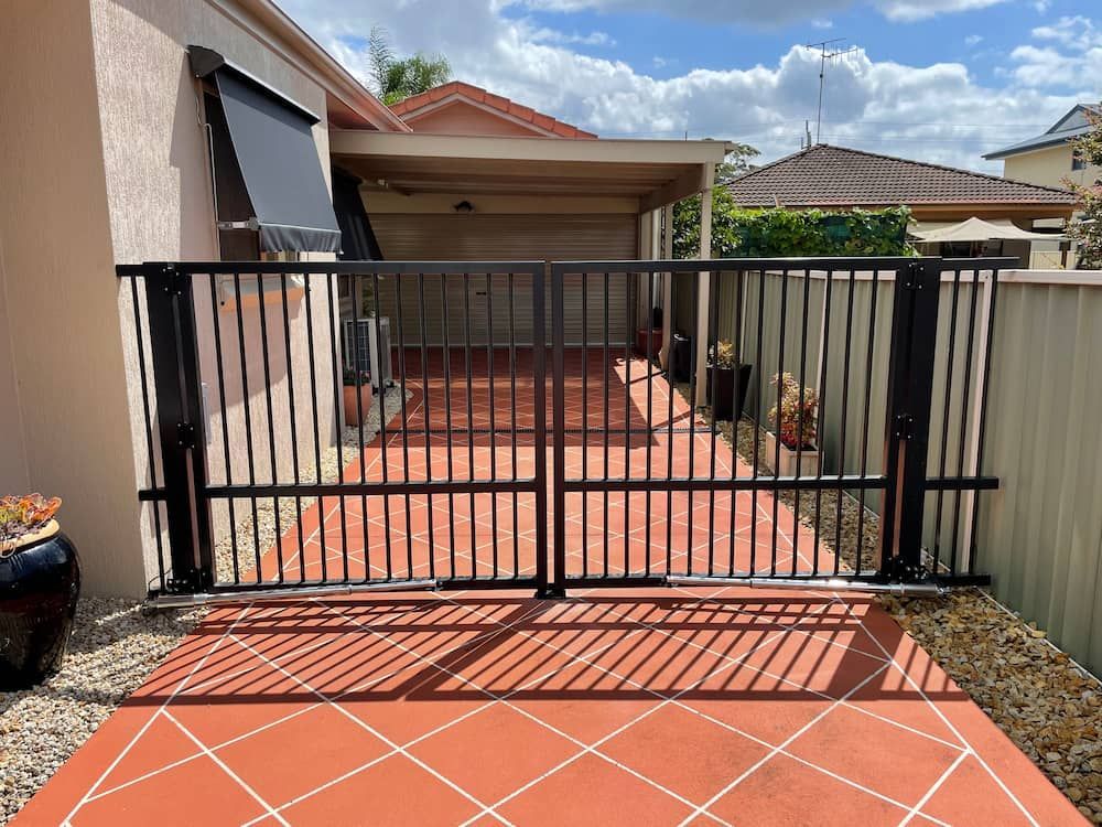 A Black Gate is Sitting in Front of a House — Riverside Aluminium & Stainless in Gloucester, NSW