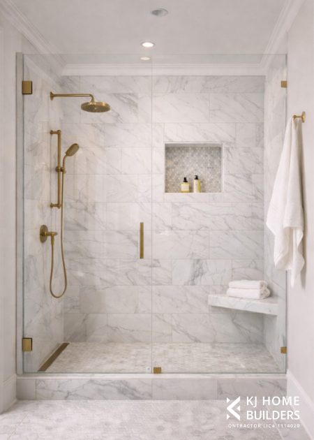 Minimal white marble bathroom with gold shower fixtures, built-in niche, and glass enclosure