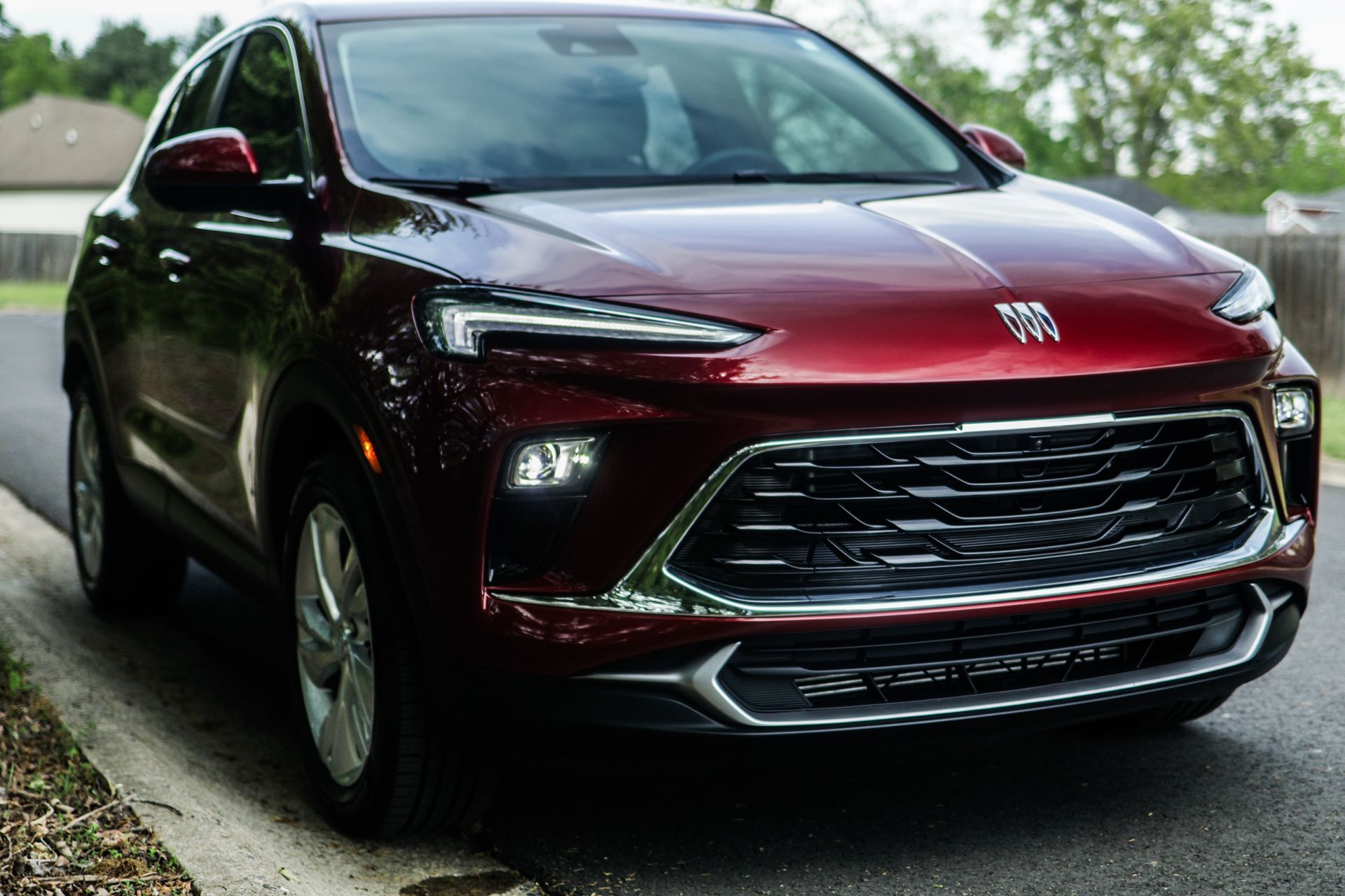 Red SUV parked on a road; front view showing headlights, grill, and chrome accents.