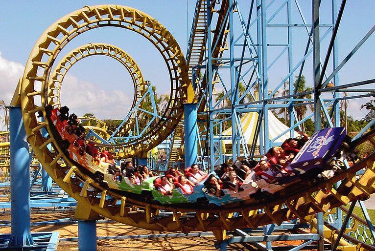 Montanha-russa com passageiros passando por um looping em um parque de diversões.