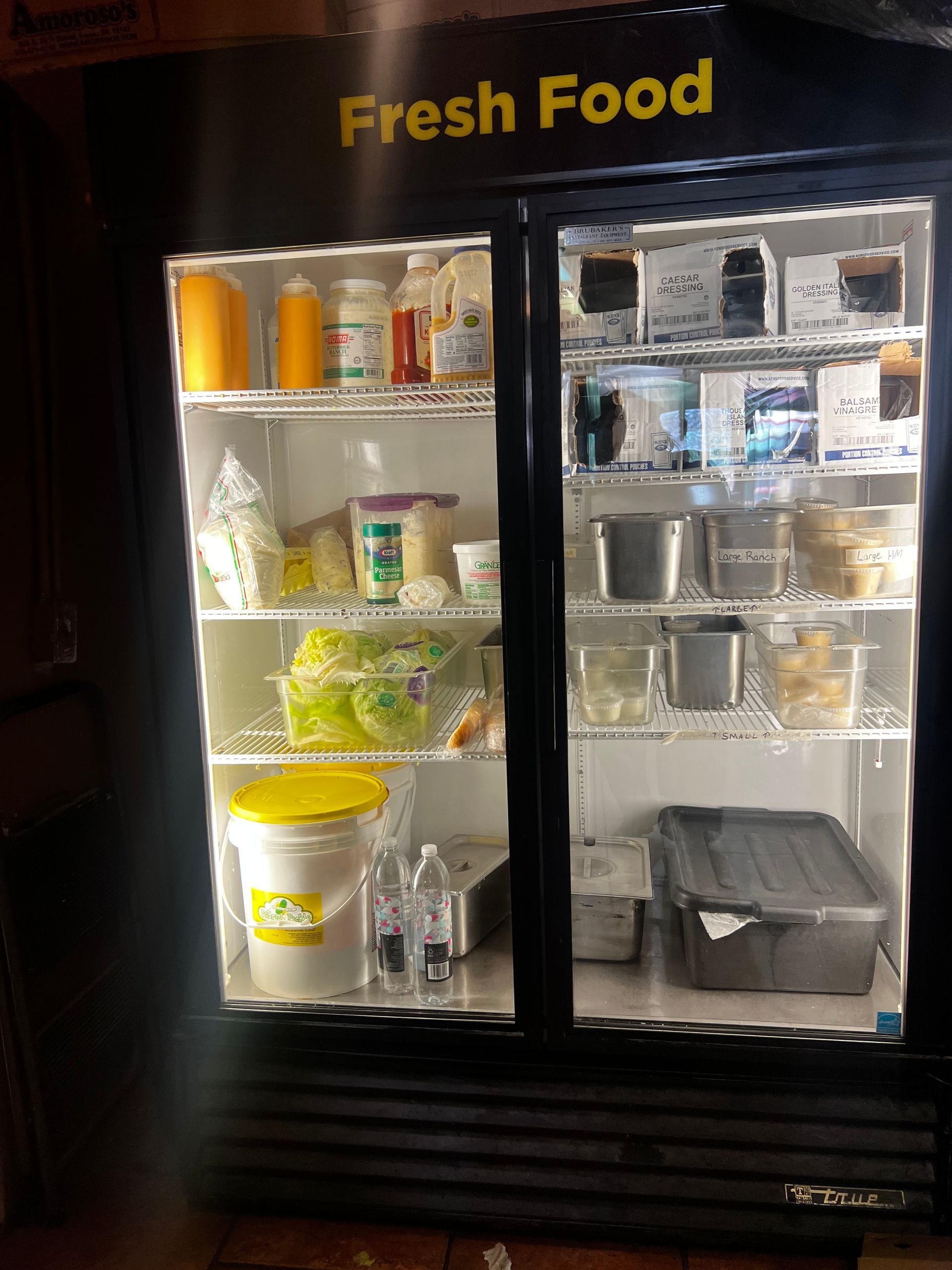 Lit refrigerated drink and snack display labeled “Fresh Food” in a store.