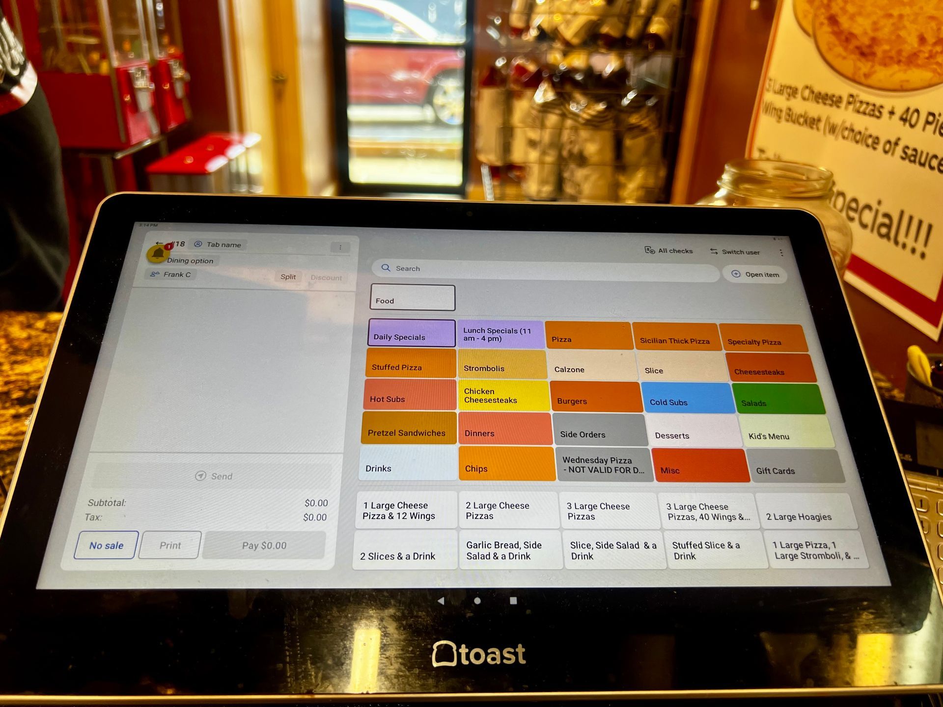 Touchscreen restaurant ordering tablet with colorful menu tiles on a counter