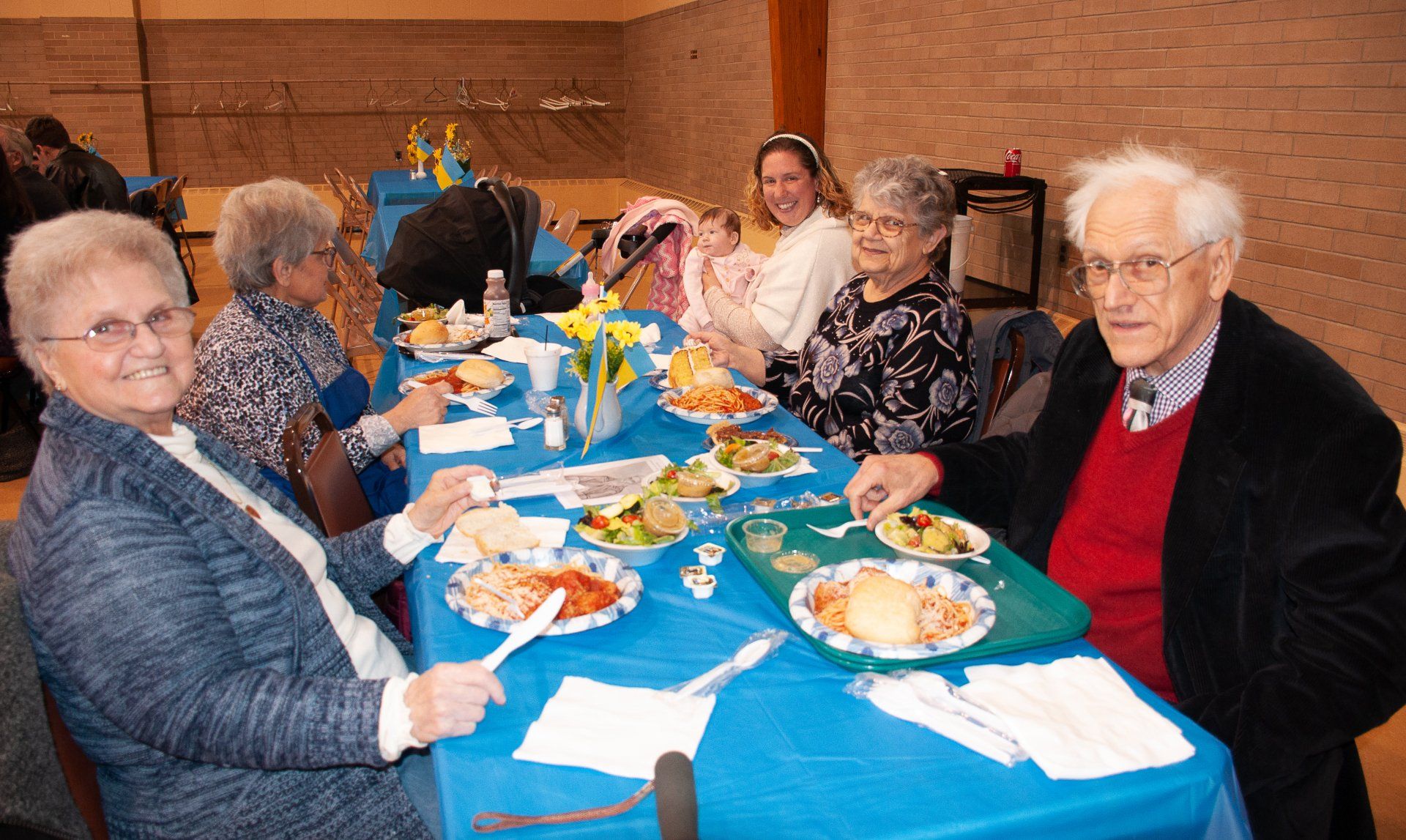 People seated around a table with plates of food in a warm indoor dining hall
