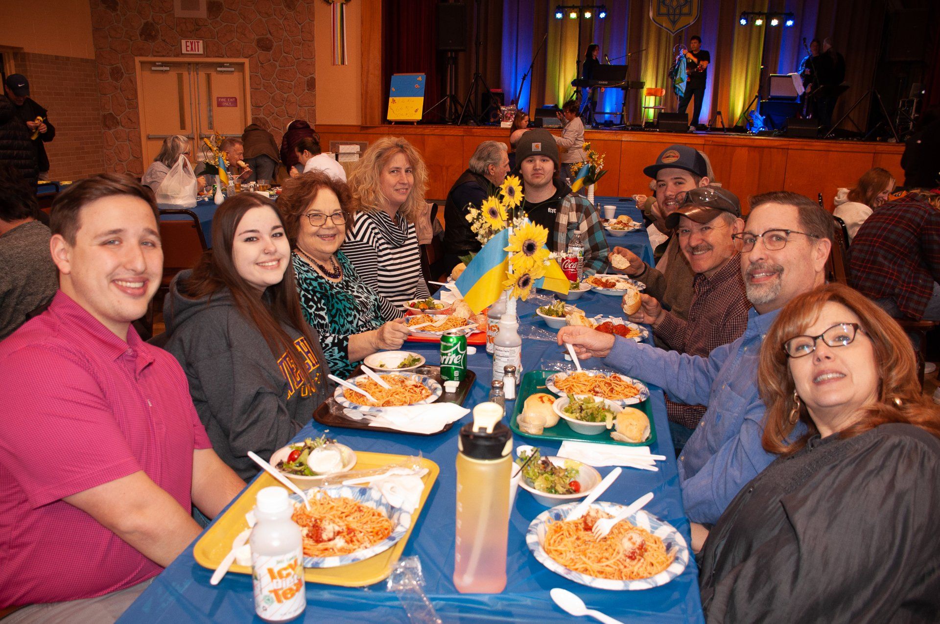 Group of people smiling around a banquet table at a festive indoor gathering