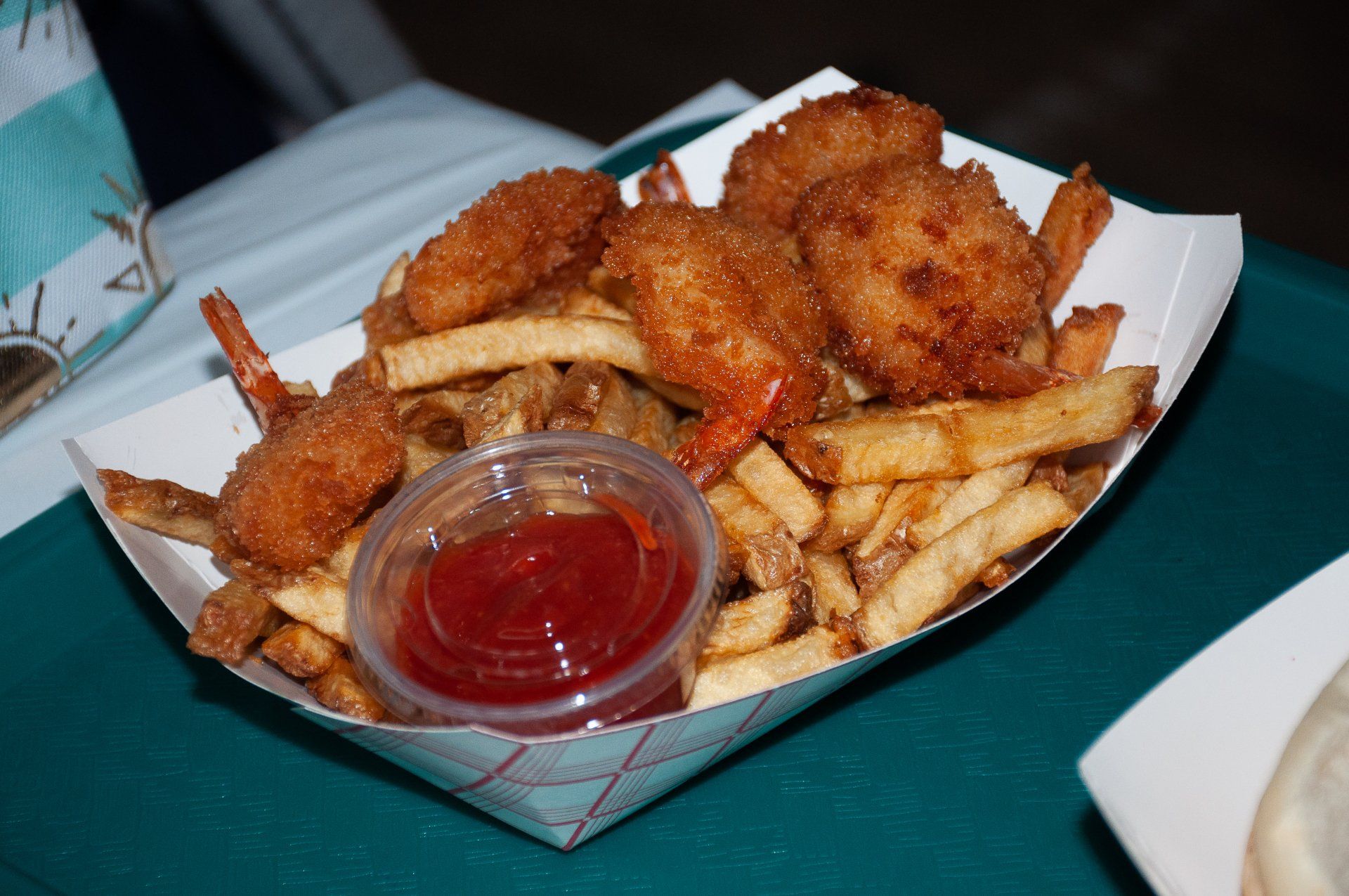 Tray of fried food and French fries with a small cup of ketchup