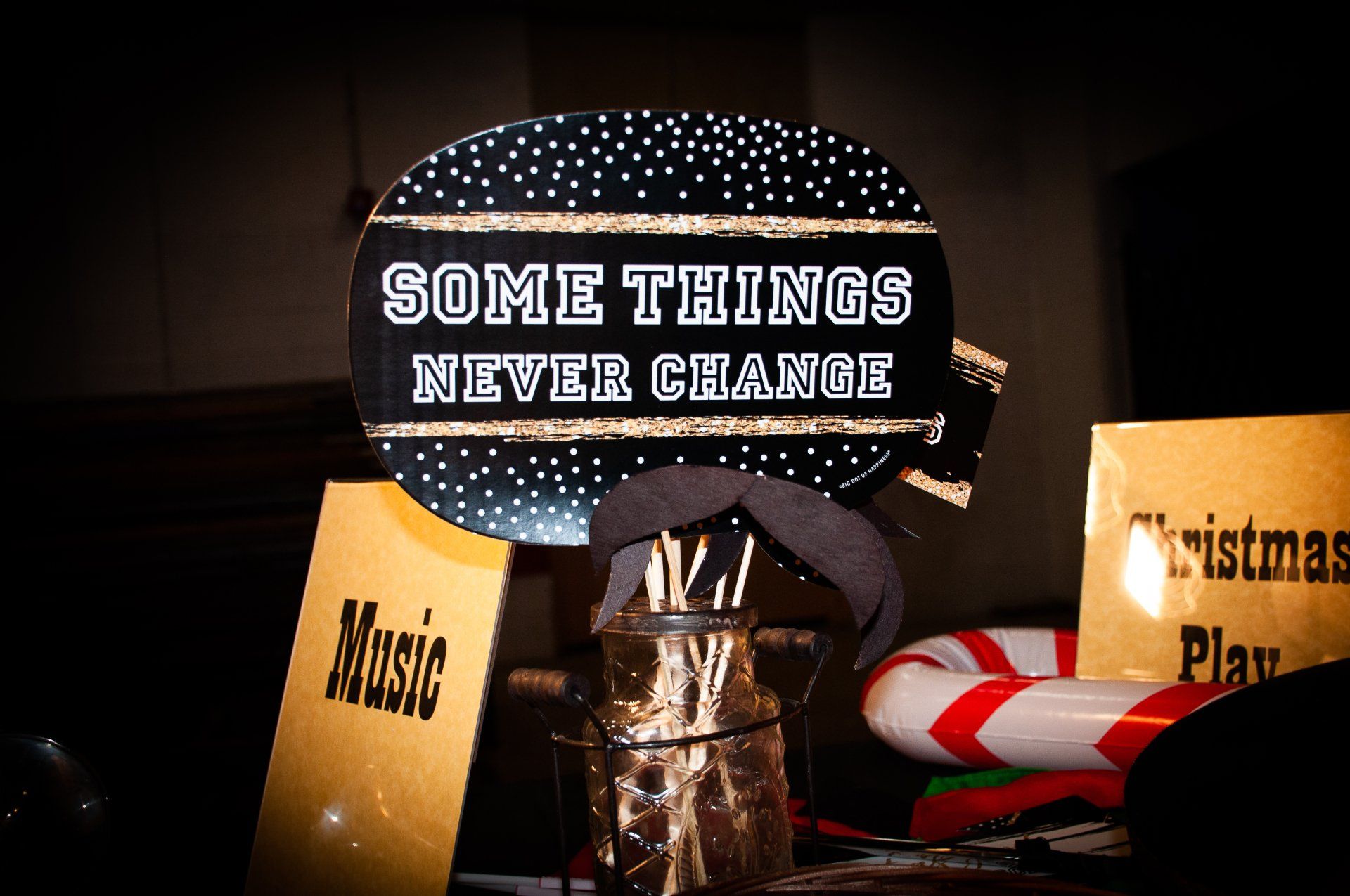 Decorative sign reading “SOME THINGS NEVER CHANGE” amid holiday items and gift boxes