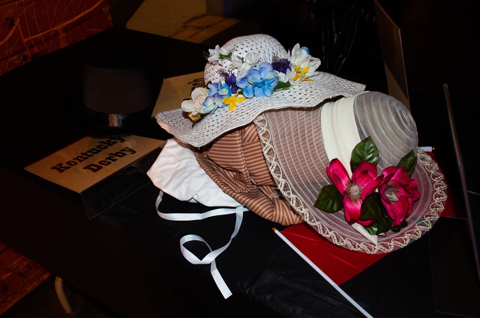 Vintage hats with lace and flowers resting on a table