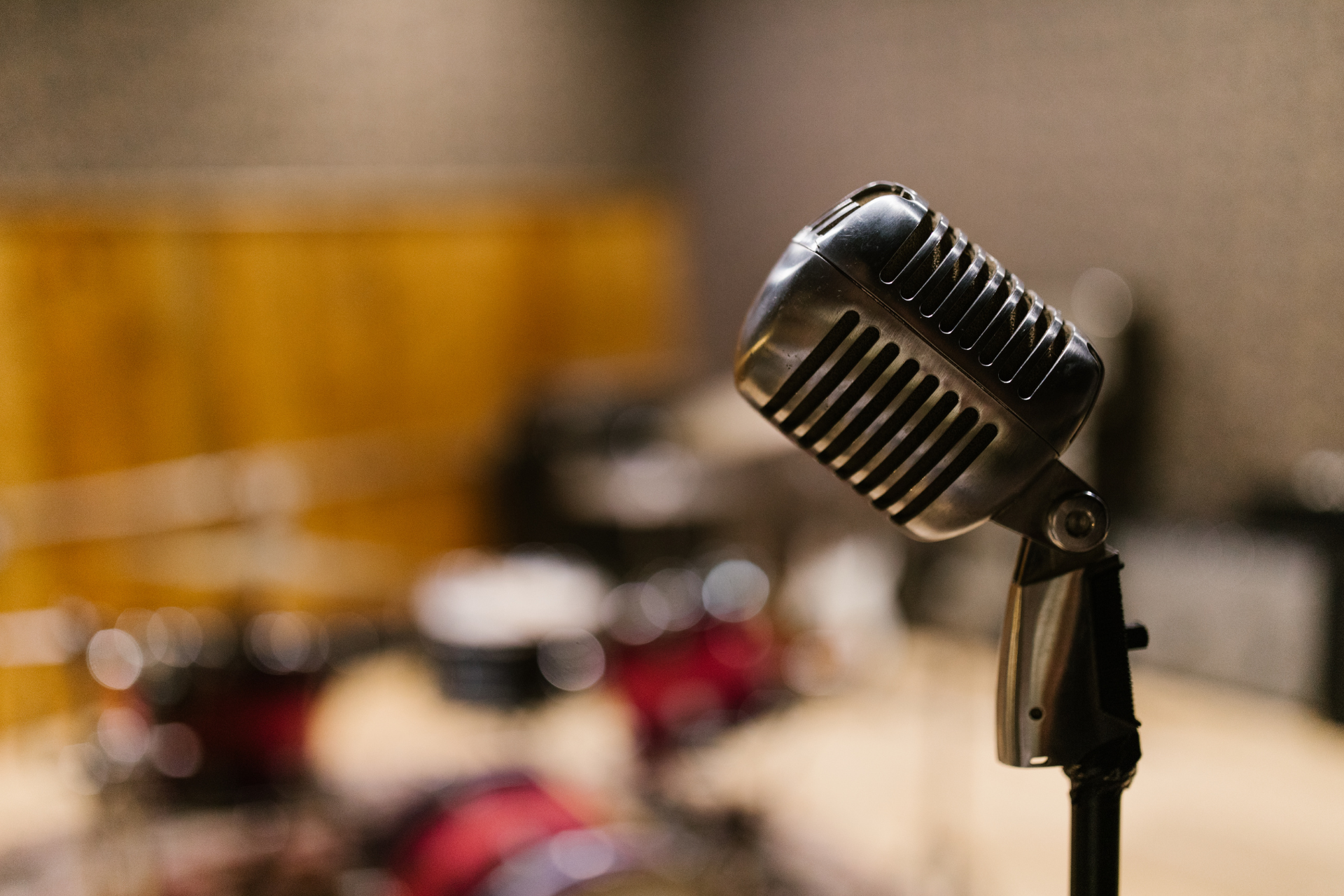 Retro microphone on a stand in a blurred studio or stage setting