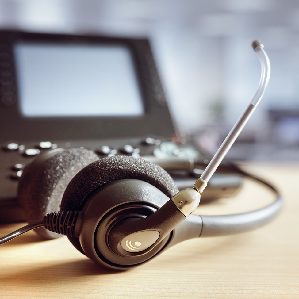 A headset is sitting on a desk in front of a computer