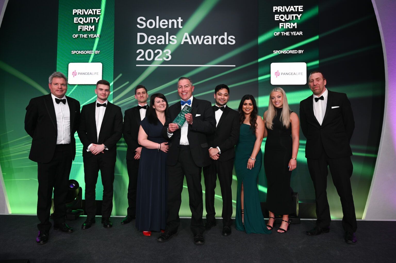 A group of people standing in front of a sign that says solent deals awards