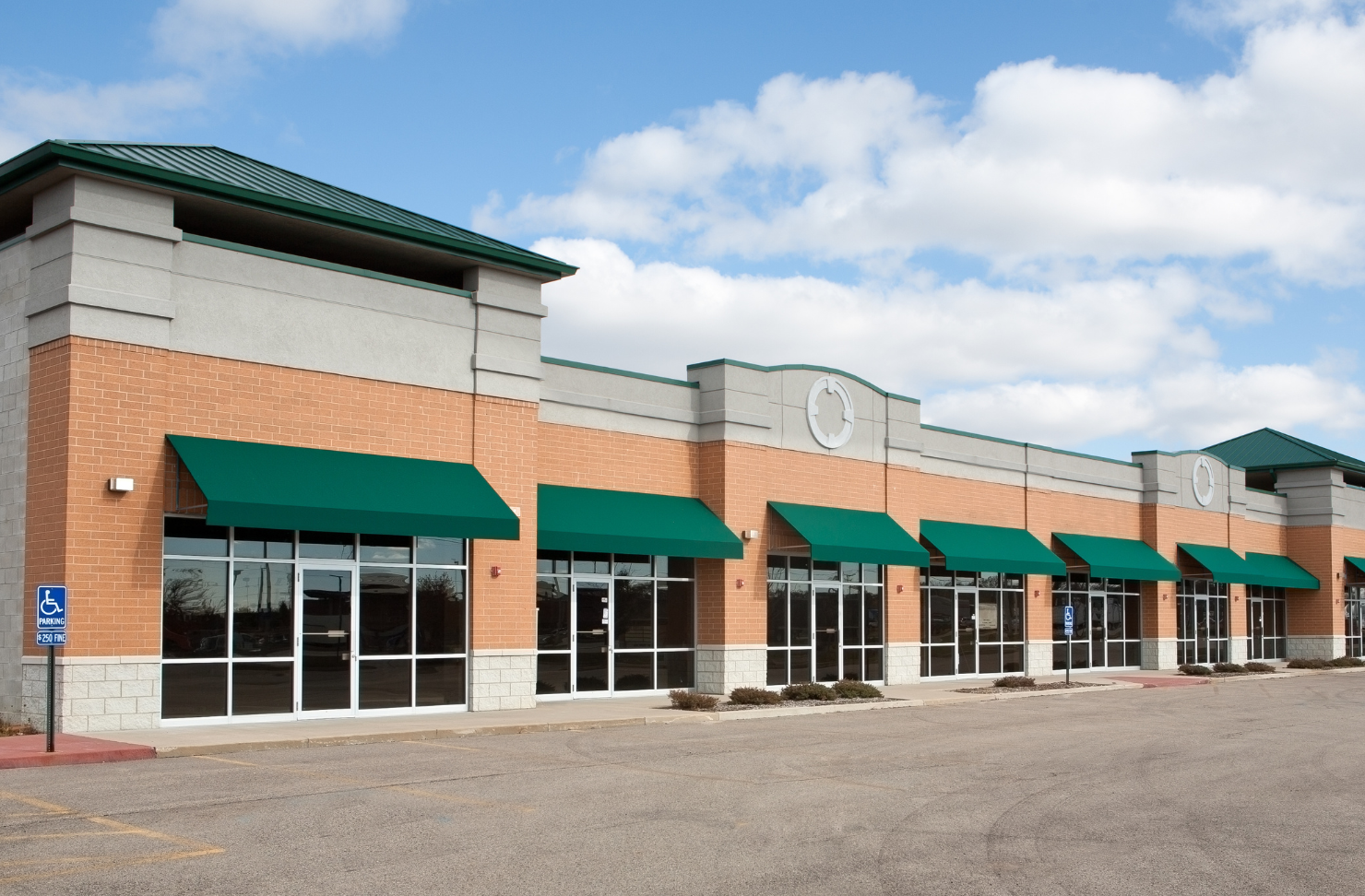 A brick building with green awnings on the windows