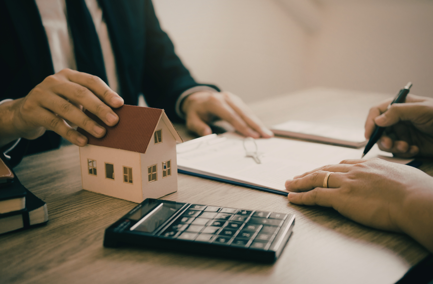A woman is holding a model house and keys in her hands.