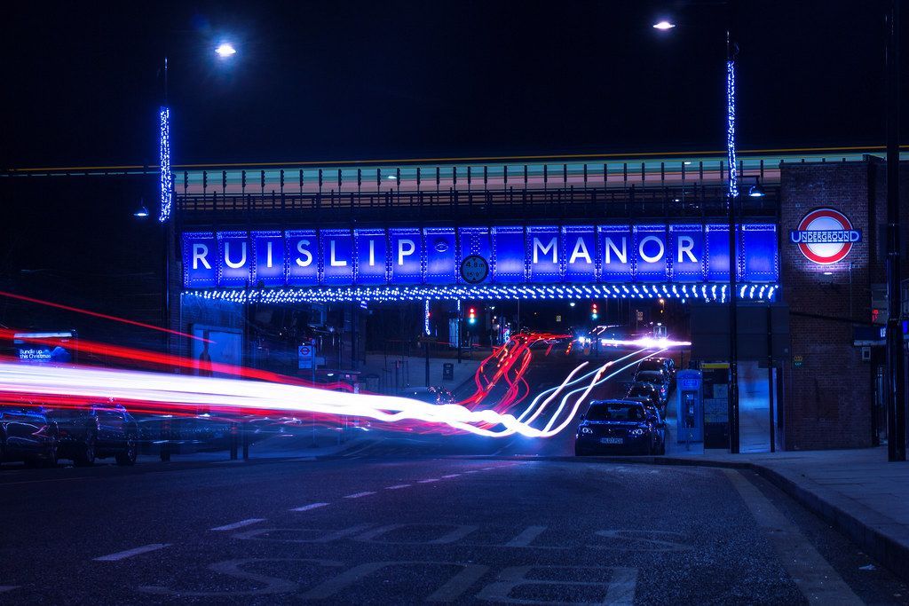 Ruislip Manor Underground station bridge lit up at night