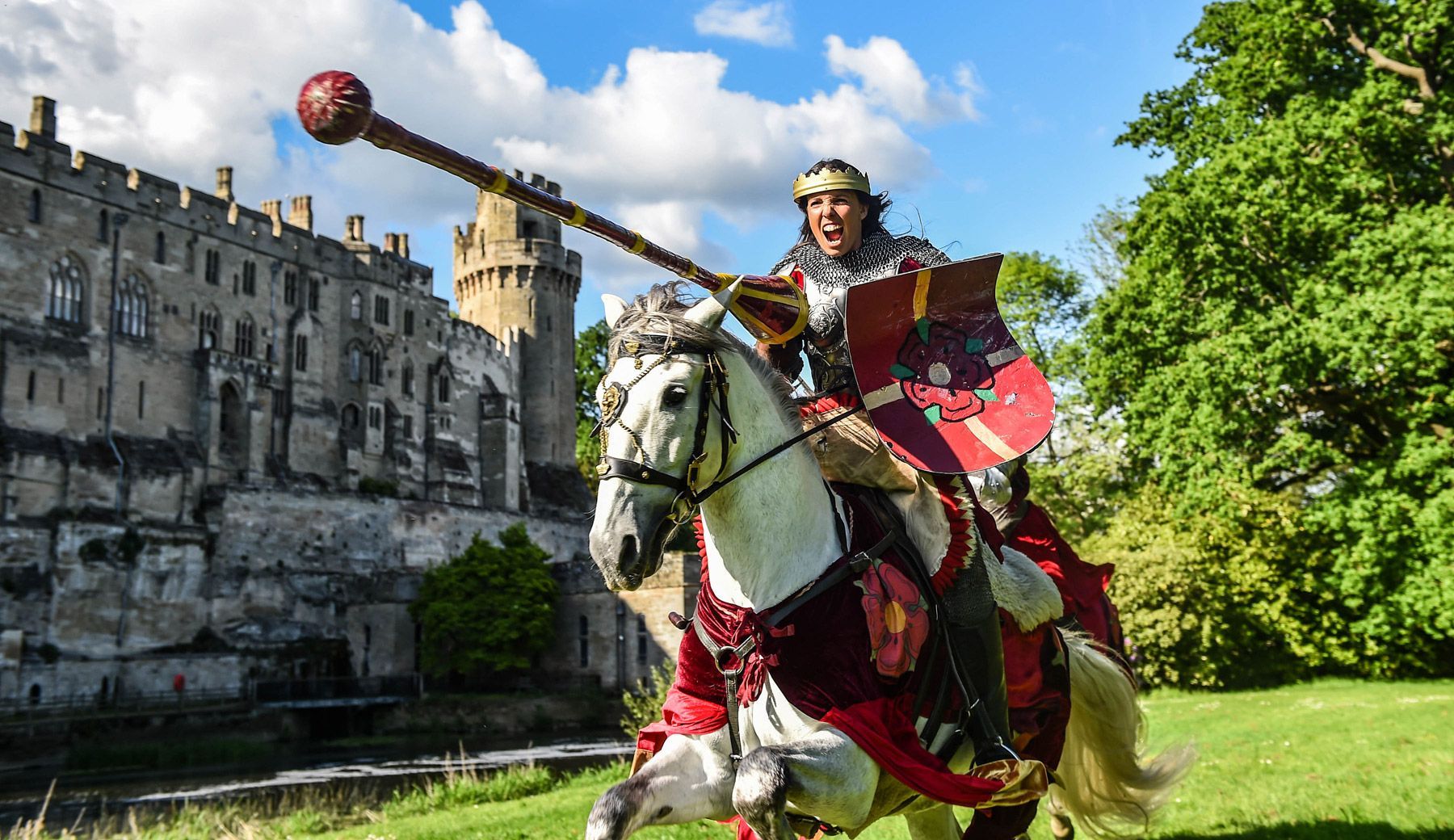Knight on horseback in front of a castle, holding a mace.