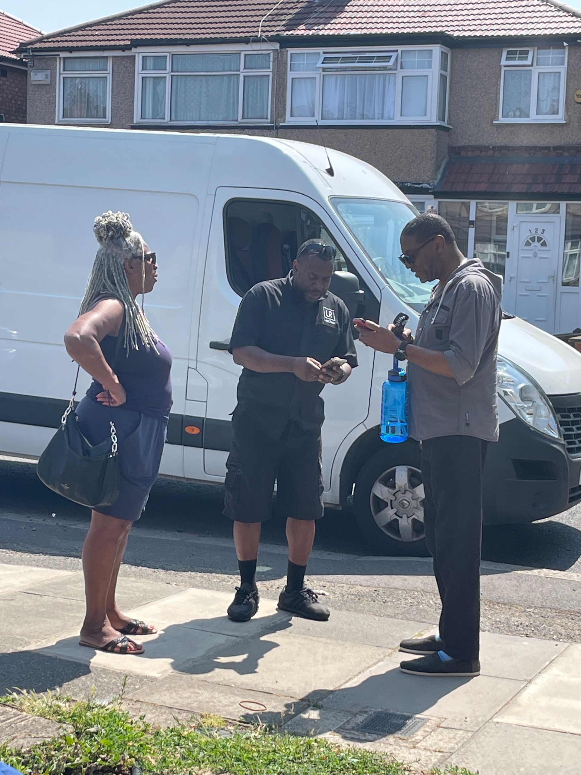 Light Rock Removals mover discussing the move with customers beside the van