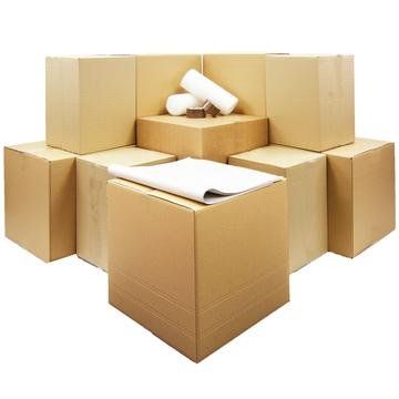 Cardboard moving boxes stacked in a pile, some with packing supplies like paper and tape.