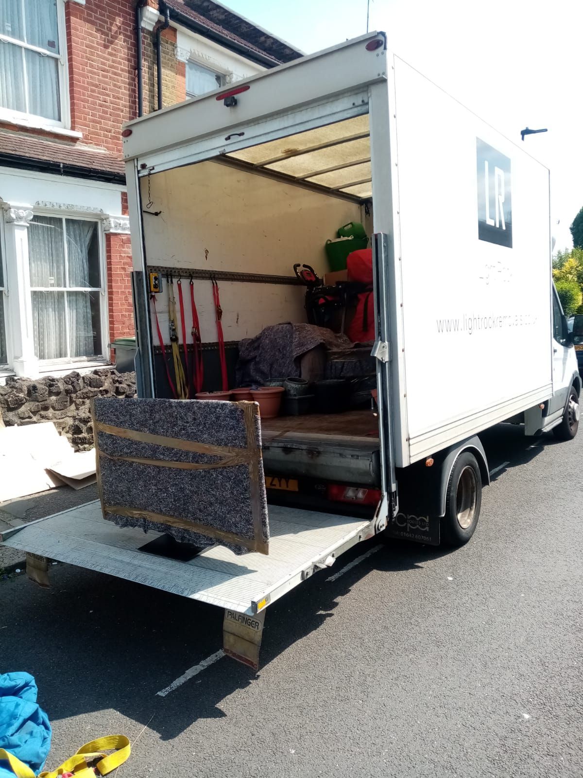 Light Rock Removals van with tail lift down and blanket-wrapped furniture ready to unload
