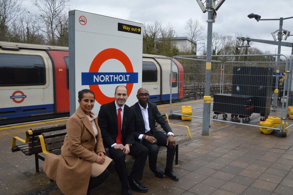 Three people on a bench at Northolt Underground station