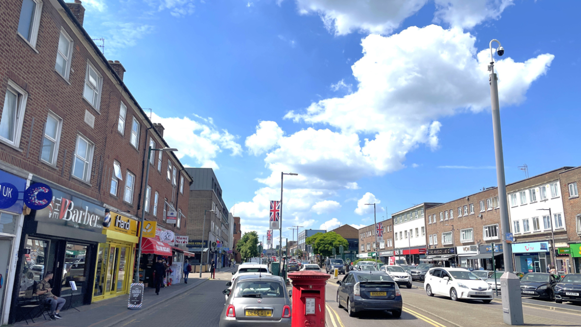 Shenley Road, Borehamwood high street with shops and a red postbox