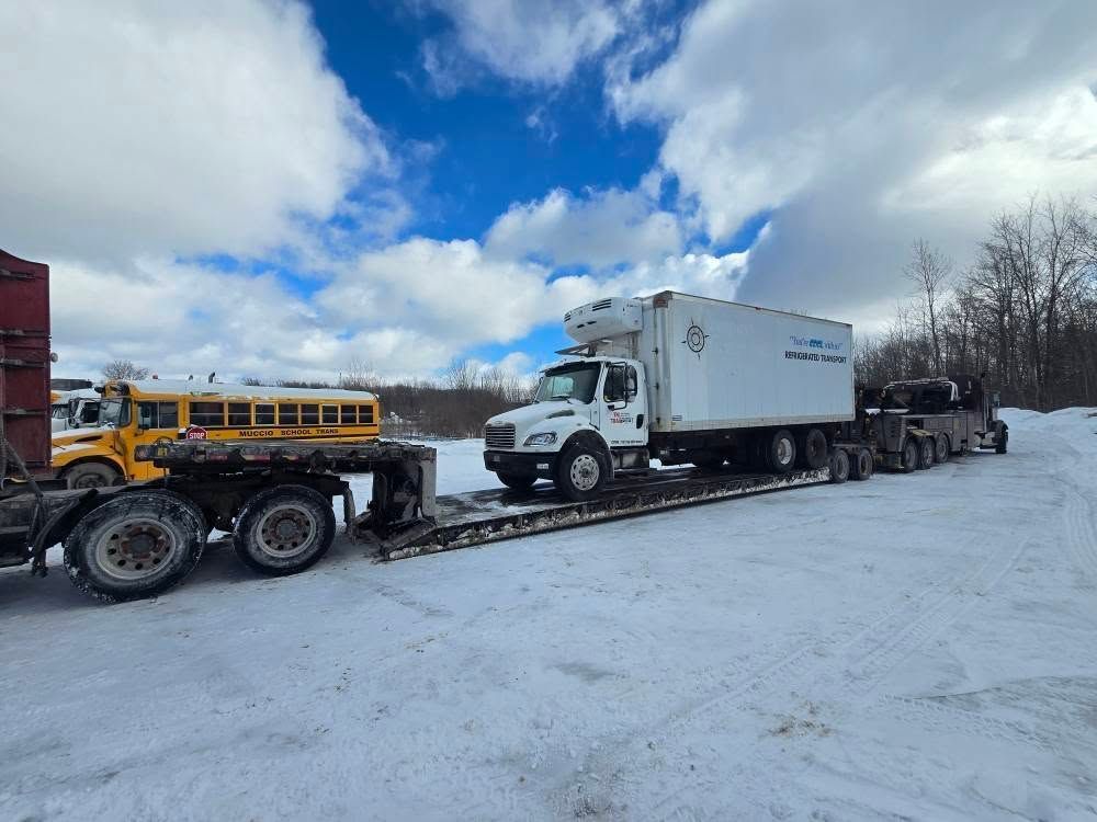 A group of semi trucks are driving down a snow covered highway. A group of semi trucks are driving down a snow covered highway.