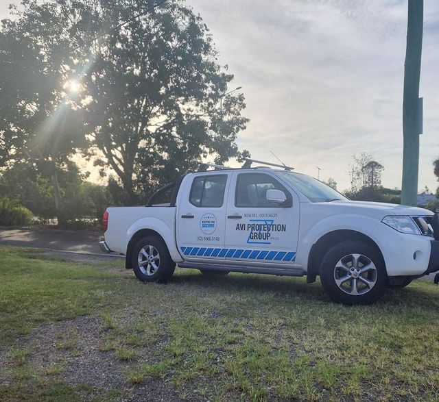 A White Pickup Truck is Parked in a Grassy Area — AVI Protection Group Pty Ltd in West Kempsey, NSW