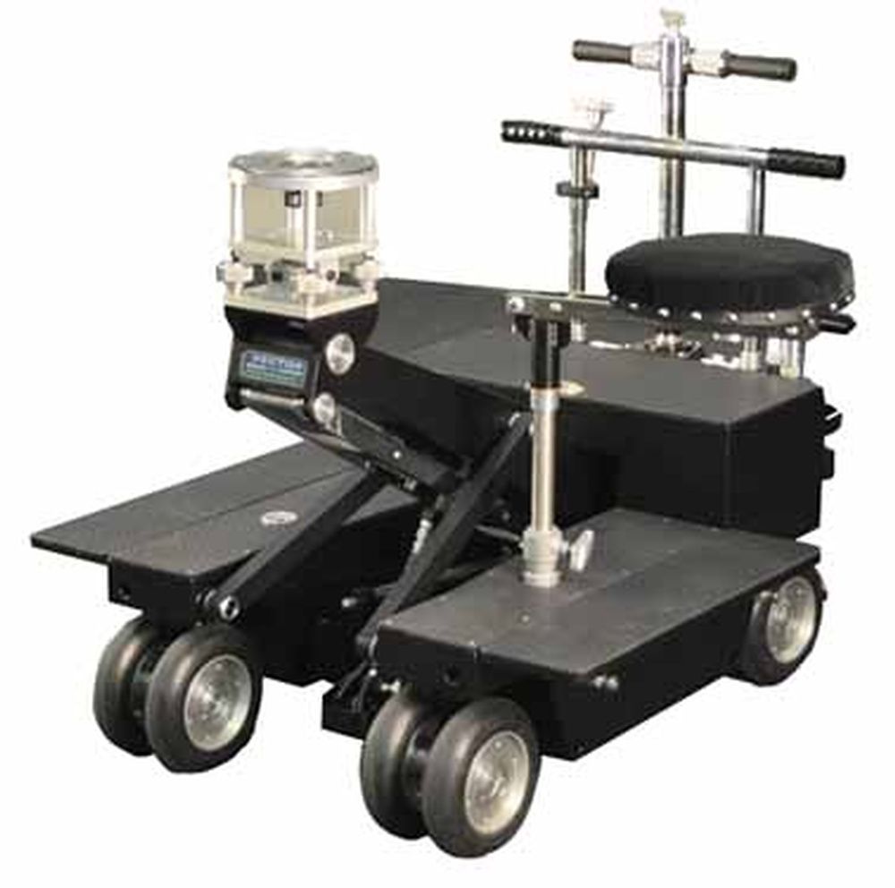 A black trolley with a stool and a camera on top of it.